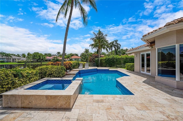 view of pool with french doors, a patio, an in ground hot tub, and a fenced backyard