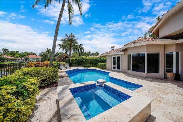 view of swimming pool featuring a patio, fence, french doors, a fenced in pool, and an in ground hot tub