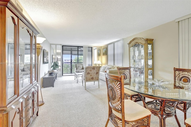 dining space with a wall of windows, light colored carpet, and a textured ceiling