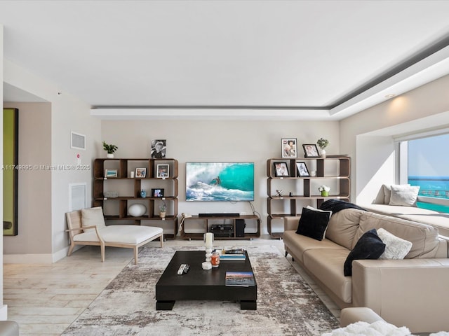 living area featuring visible vents, baseboards, and wood finished floors