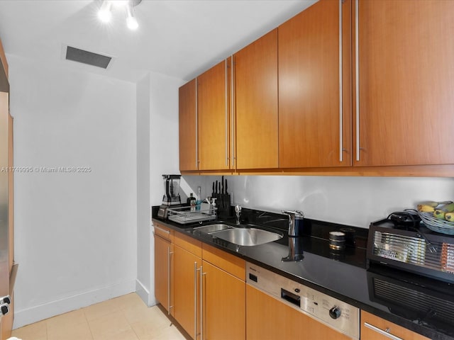 kitchen with visible vents, a sink, paneled dishwasher, light tile patterned floors, and baseboards