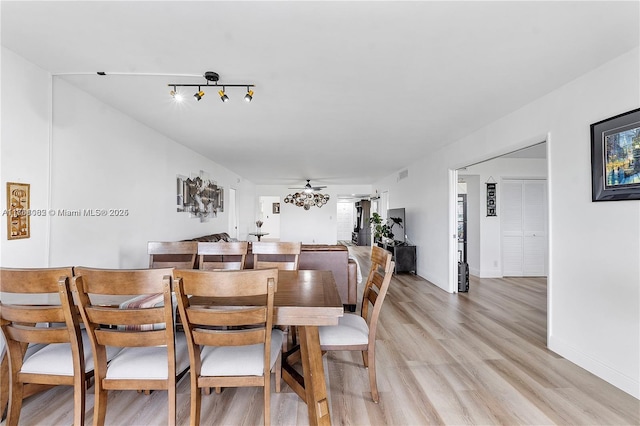 dining space featuring baseboards, light wood-style flooring, and a ceiling fan