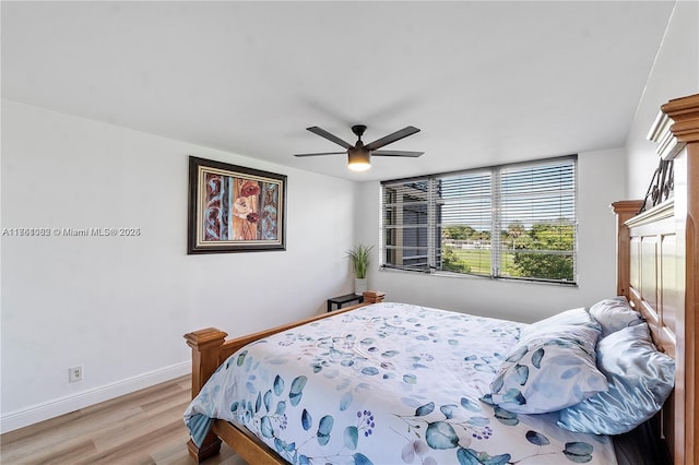 bedroom with baseboards, light wood finished floors, and ceiling fan