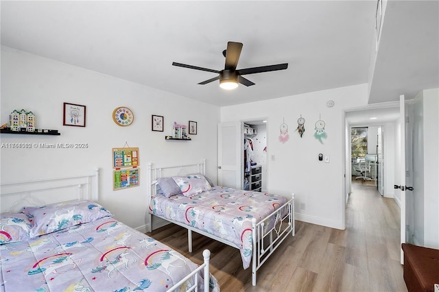 bedroom featuring ceiling fan, baseboards, and wood finished floors