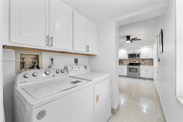 washroom featuring washer and dryer, light tile patterned floors, cabinet space, and baseboards