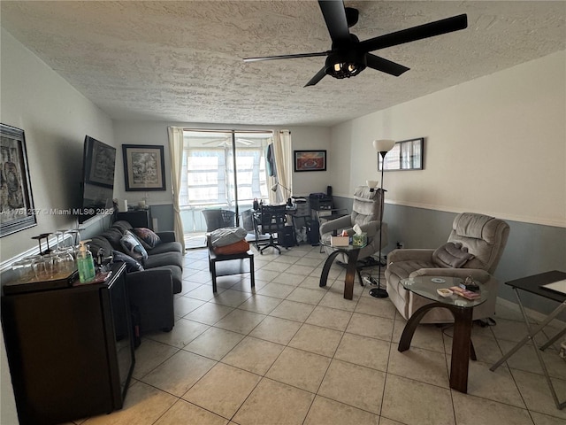 living room featuring light tile patterned floors, a textured ceiling, and ceiling fan