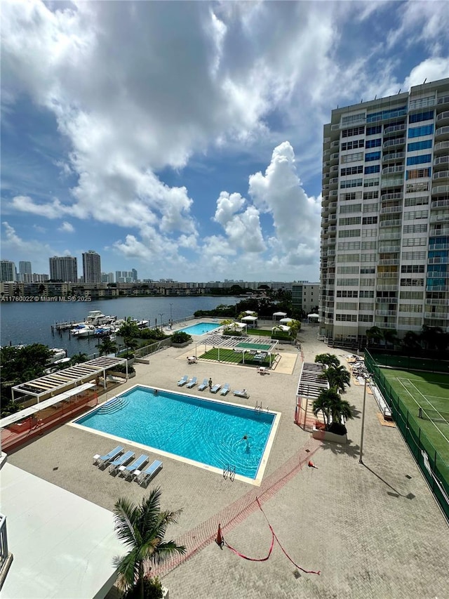 community pool featuring a city view, a patio, and a water view