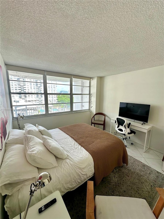 bedroom with a textured ceiling and tile patterned flooring