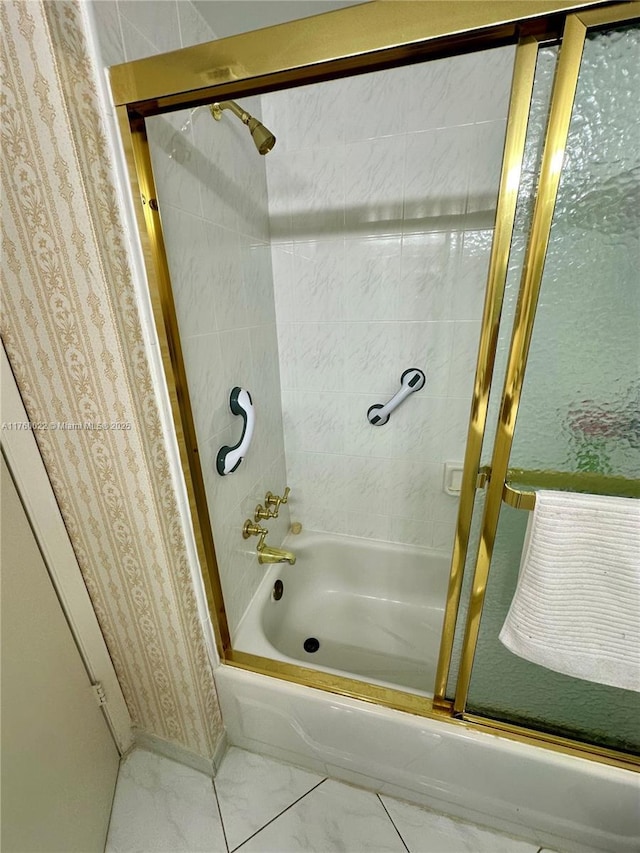 full bathroom featuring bath / shower combo with glass door and marble finish floor