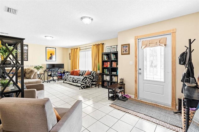 entrance foyer featuring light tile patterned floors, visible vents, and a textured ceiling