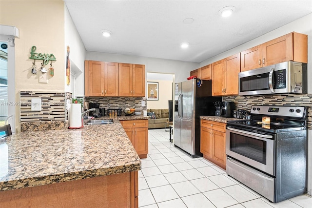 kitchen with light tile patterned flooring, a sink, light countertops, appliances with stainless steel finishes, and backsplash