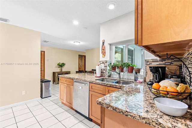 kitchen with visible vents, a peninsula, light tile patterned flooring, a sink, and dishwasher