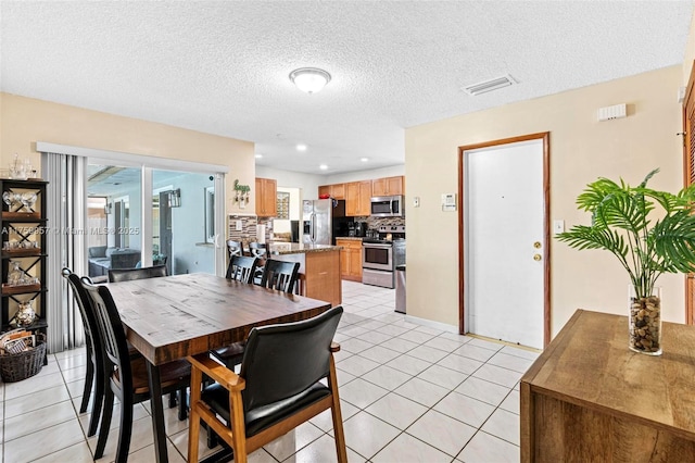 dining area featuring light tile patterned floors, recessed lighting, visible vents, and a textured ceiling