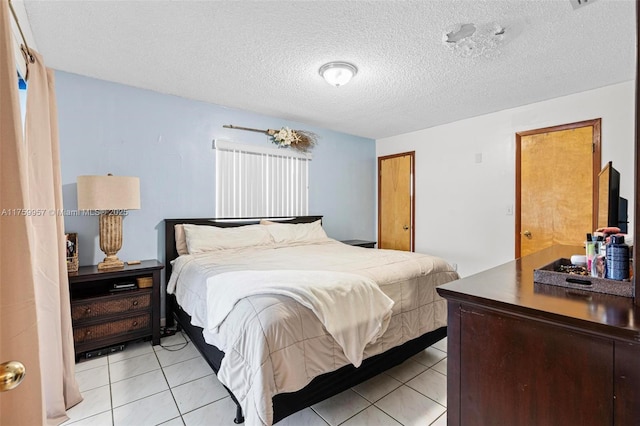 bedroom featuring light tile patterned flooring, a textured ceiling, and a closet