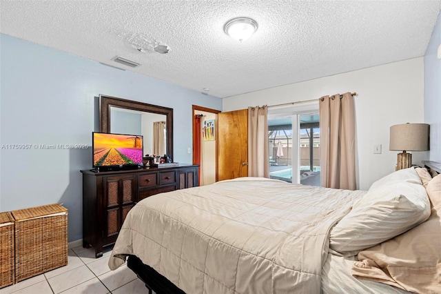 bedroom with light tile patterned floors, visible vents, a textured ceiling, and access to outside