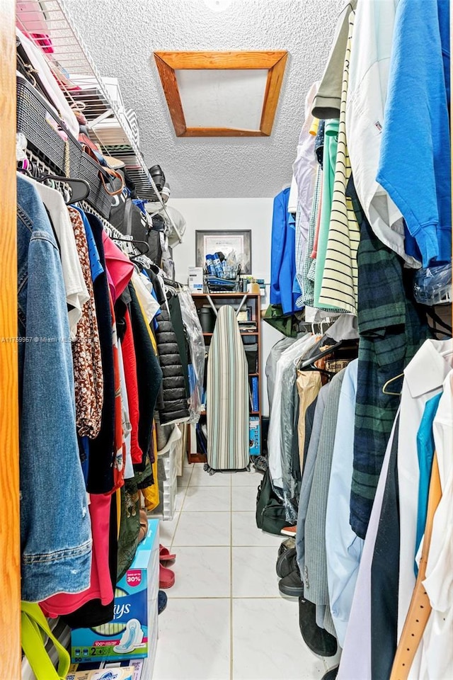 spacious closet with attic access and tile patterned flooring