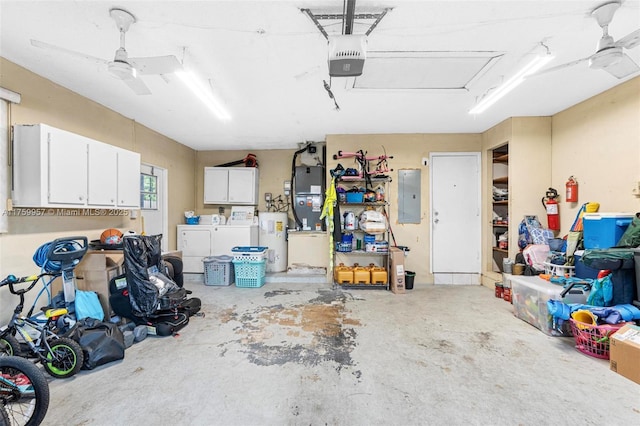 garage featuring electric panel, a garage door opener, washing machine and dryer, water heater, and ceiling fan