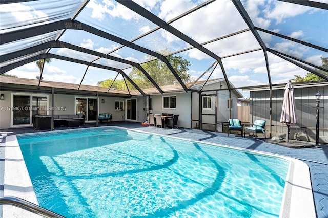 pool featuring glass enclosure, outdoor lounge area, and a patio area