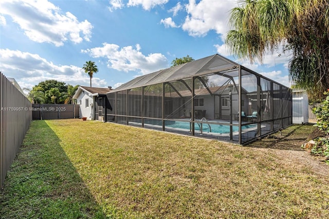 view of pool with a lanai, a fenced in pool, a fenced backyard, and a lawn