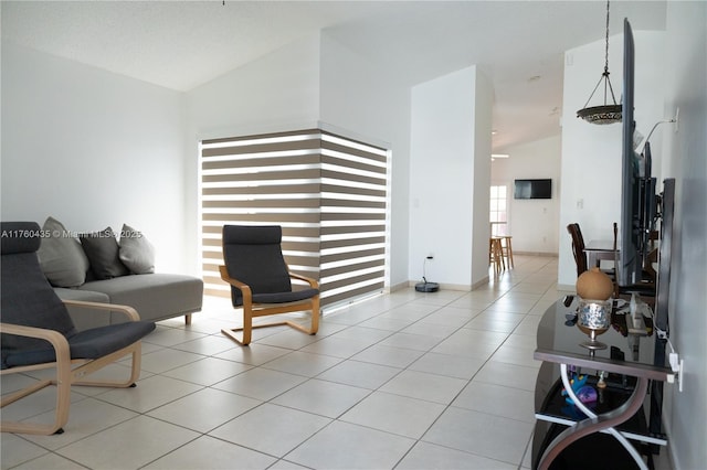 tiled living room featuring baseboards and high vaulted ceiling