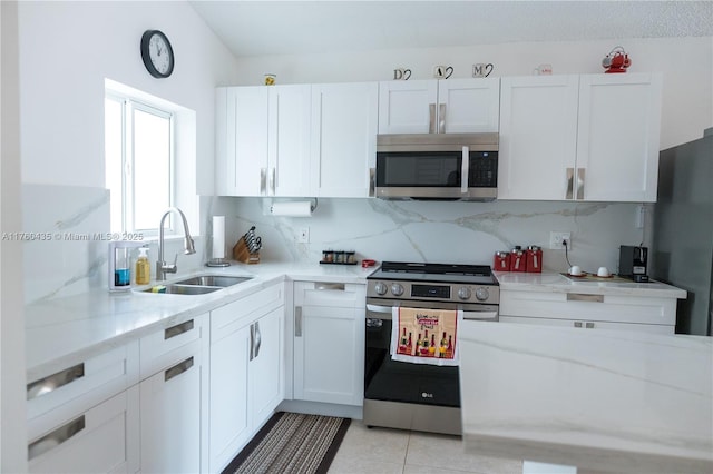 kitchen with decorative backsplash, white cabinetry, stainless steel appliances, and a sink