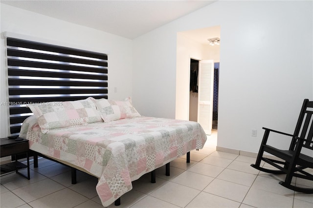 tiled bedroom featuring baseboards and lofted ceiling