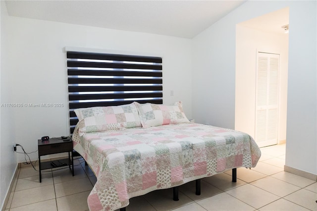 tiled bedroom featuring baseboards