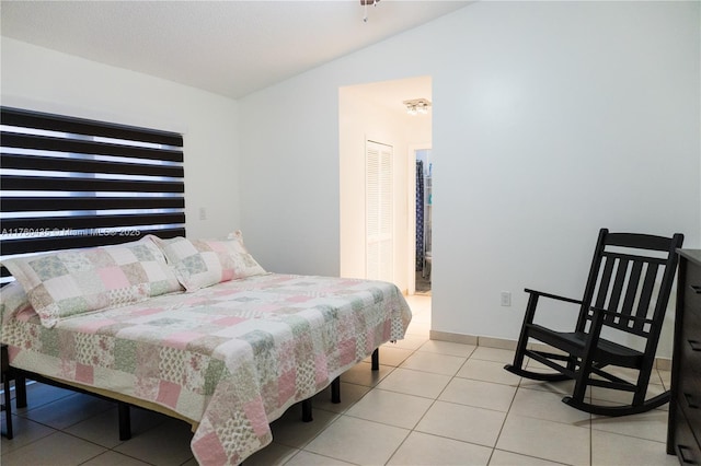 tiled bedroom featuring vaulted ceiling and baseboards