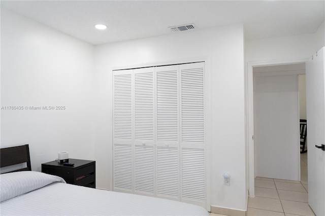 bedroom featuring light tile patterned floors, visible vents, a closet, and recessed lighting