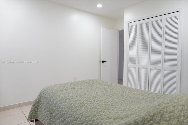 bedroom featuring light tile patterned floors, recessed lighting, a closet, and baseboards