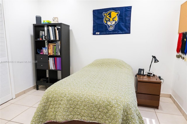 bedroom featuring tile patterned flooring and baseboards