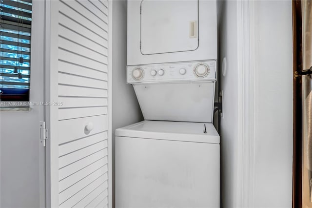 clothes washing area with stacked washing maching and dryer and laundry area