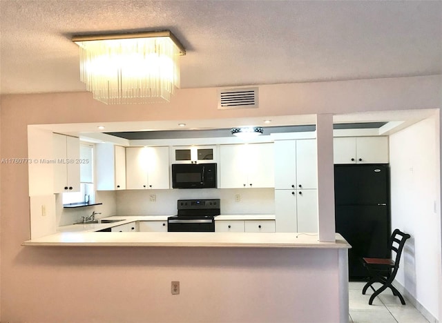 kitchen featuring black appliances, light countertops, visible vents, and a sink