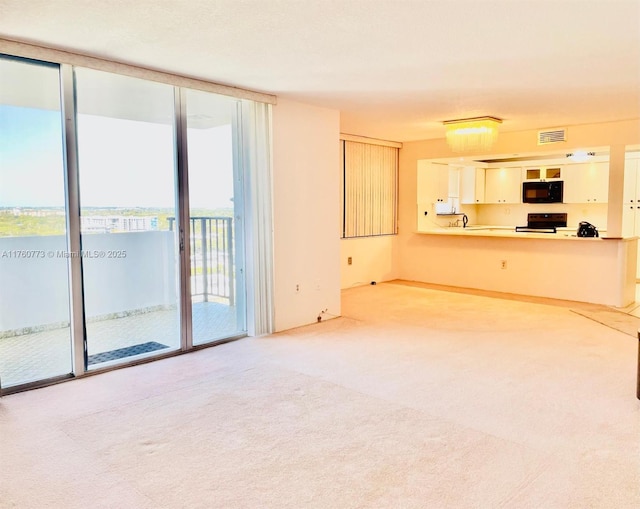 unfurnished living room with a wall of windows, visible vents, carpet, and a sink