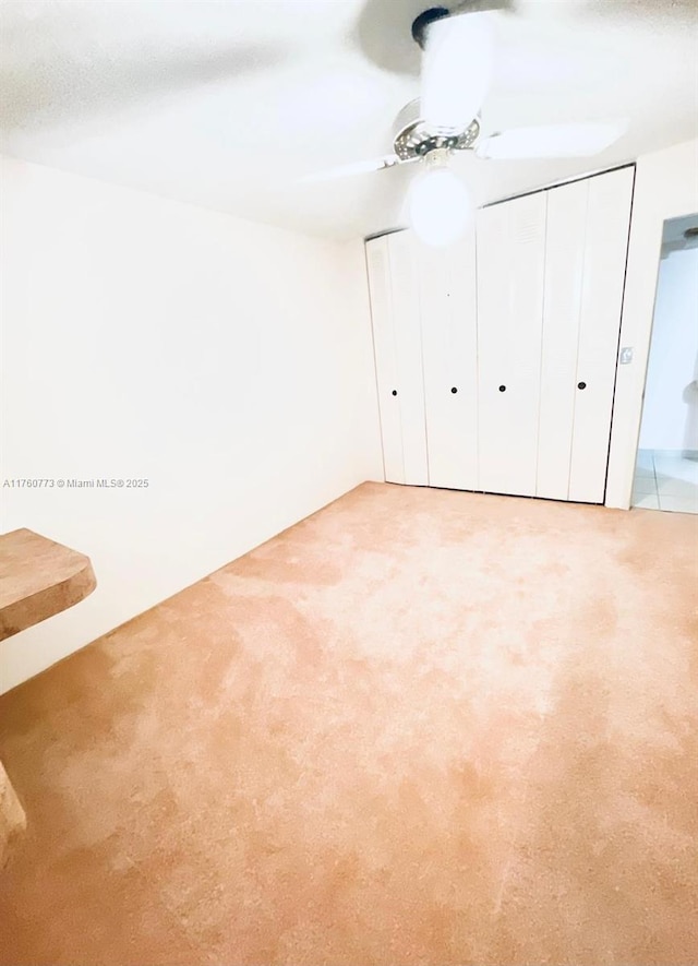 unfurnished bedroom with multiple closets, carpet, and a ceiling fan