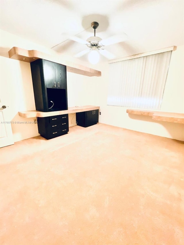 unfurnished living room with carpet and ceiling fan