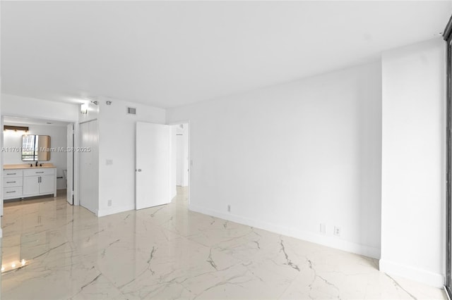 unfurnished bedroom featuring ensuite bath, baseboards, marble finish floor, and visible vents