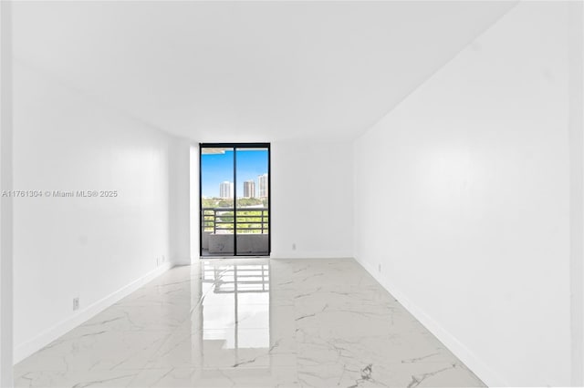 unfurnished room with marble finish floor, baseboards, and expansive windows