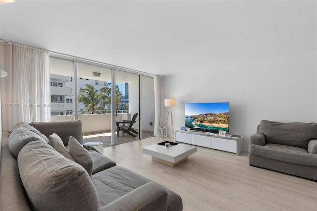 living area featuring floor to ceiling windows and light wood-style flooring