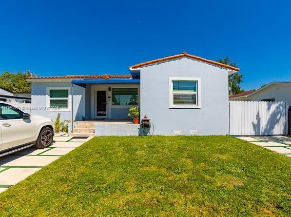 view of front facade with crawl space, stucco siding, a front lawn, and fence