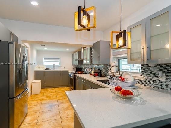 kitchen featuring gray cabinets, stainless steel appliances, a healthy amount of sunlight, and a sink