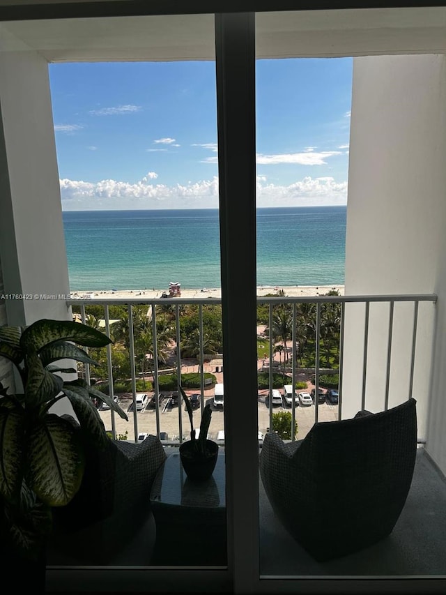 balcony featuring a beach view and a water view