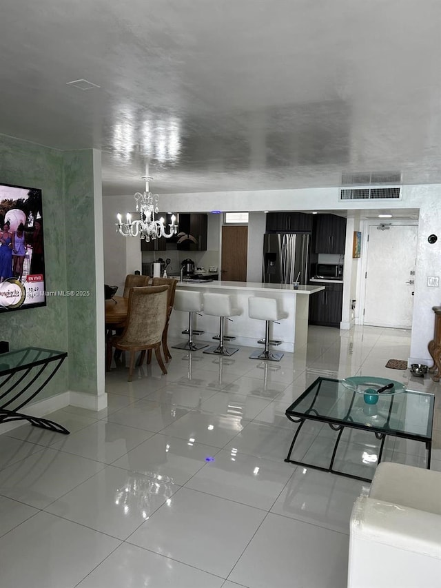 living area with an inviting chandelier, light tile patterned floors, and visible vents