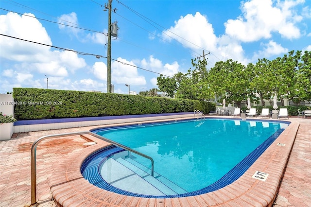 pool with a patio and fence