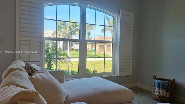 doorway to outside with baseboards, plenty of natural light, and tile patterned flooring