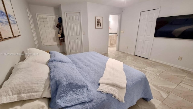 bedroom featuring baseboards, marble finish floor, and ensuite bathroom