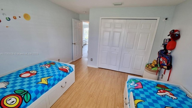 bedroom with a closet, baseboards, visible vents, and light wood-style flooring