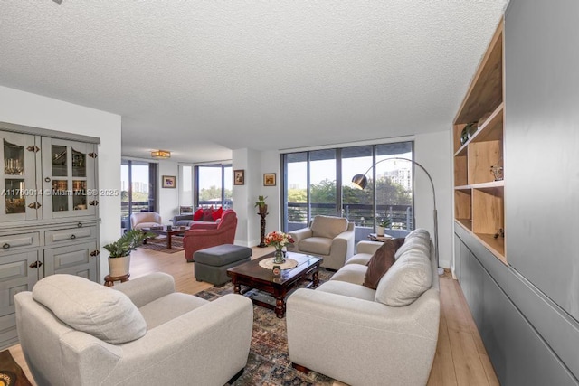 living area with light wood-type flooring, a textured ceiling, and floor to ceiling windows