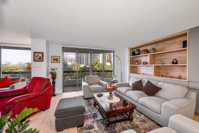 living area with a textured ceiling, wood finished floors, and floor to ceiling windows