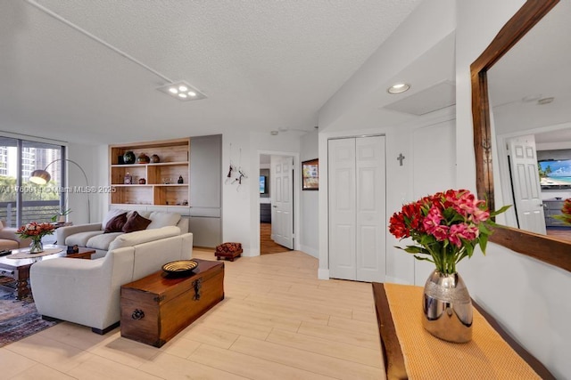 living room featuring light wood-style flooring and a textured ceiling